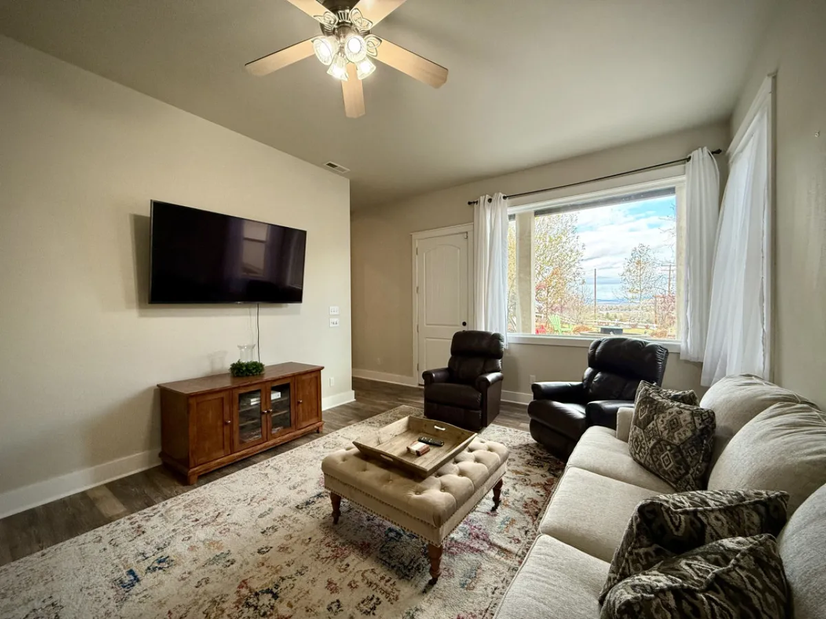 A second living room furnished with a sofa, armchair, coffee table, TV, and a window with scenic views. The setting is comfortable and versatile, perfect for quiet hangouts or a kids’ zone, just as described in the section.
