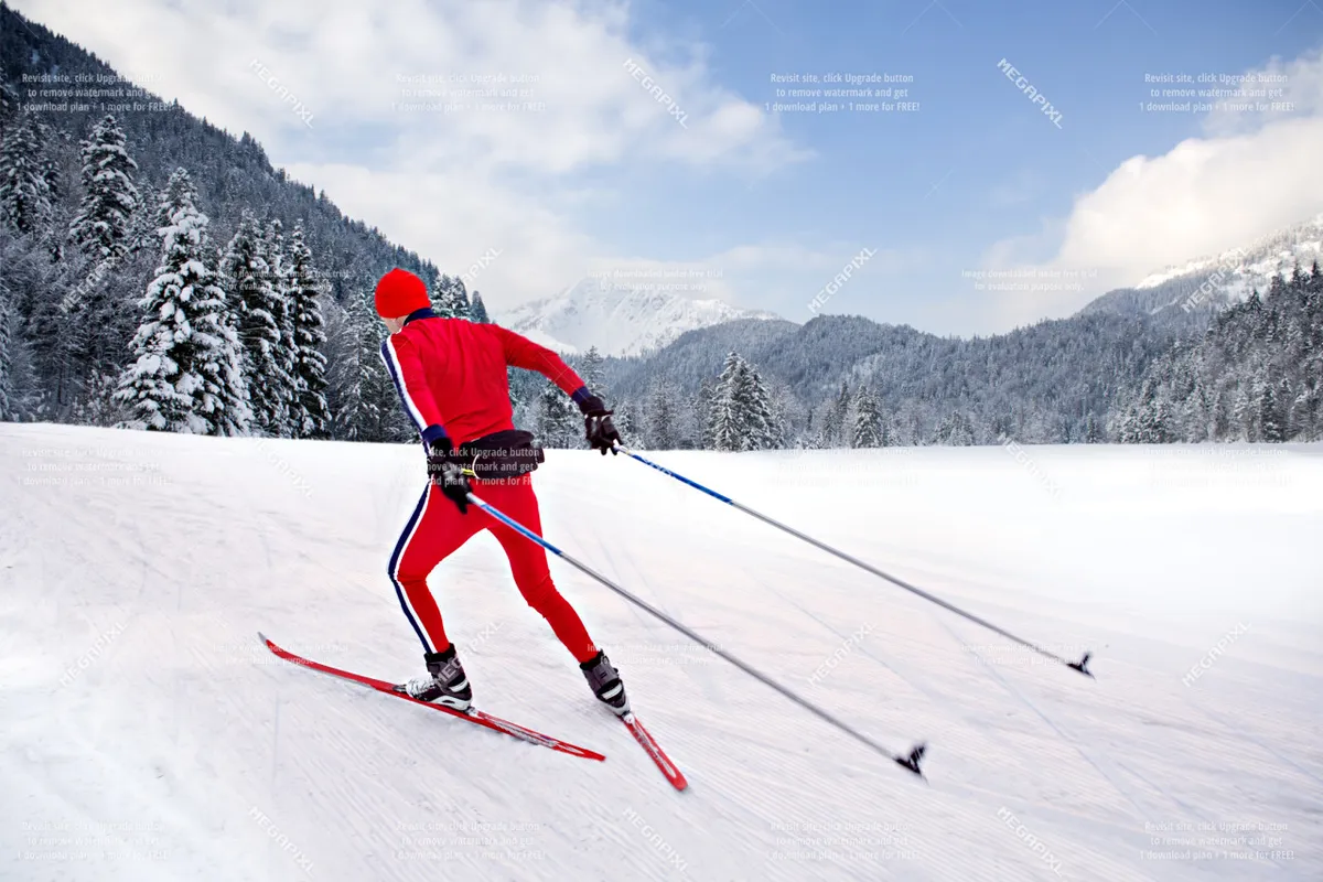 A skier glides across a snowy landscape with a stunning mountain backdrop. The snow-covered ground and evergreens evoke the pristine, adventurous spirit of winter sports. The scene captures both the excitement of skiing and the serene beauty of nature.