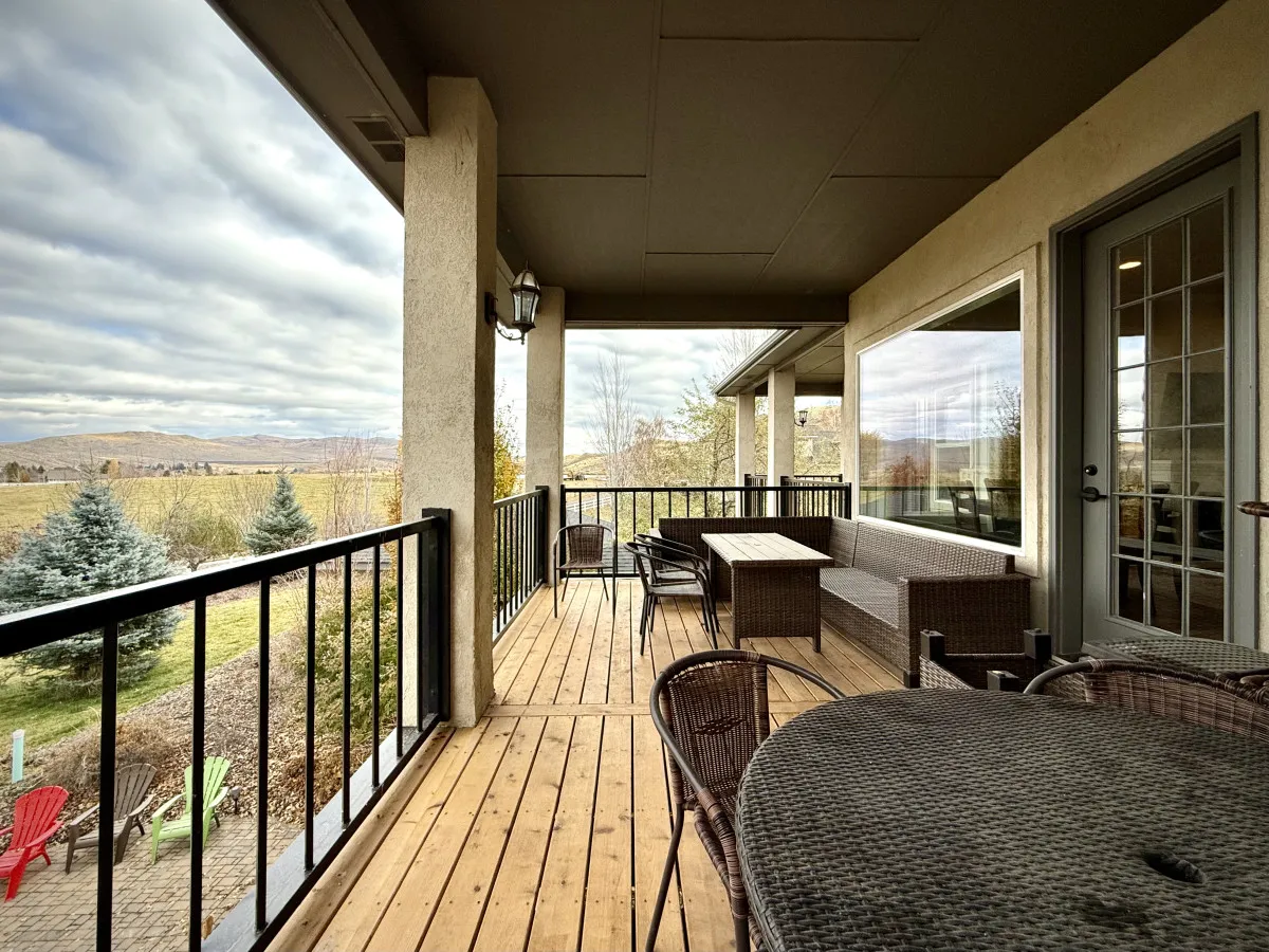 A tranquil wooden deck with comfortable outdoor seating, looking out over a beautiful landscape, ideal for relaxing, entertaining, or soaking in panoramic views.